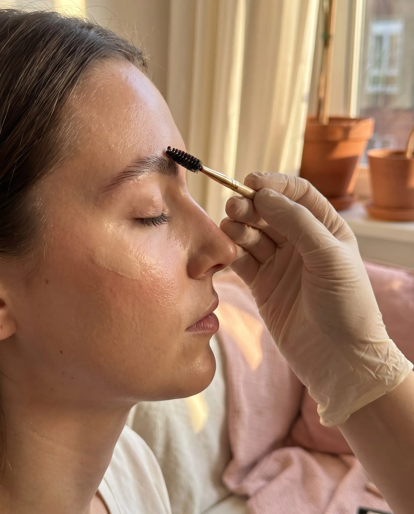 Brow lamination in progress, brushing brows into place